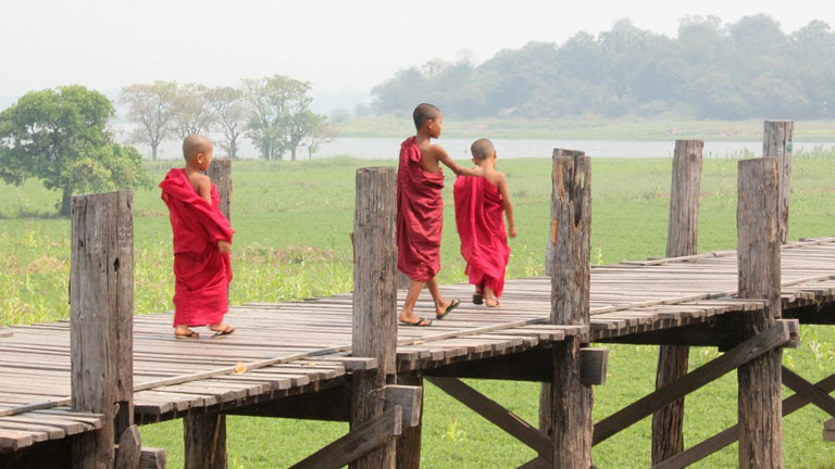 three young boys in traditional Buddhist robes